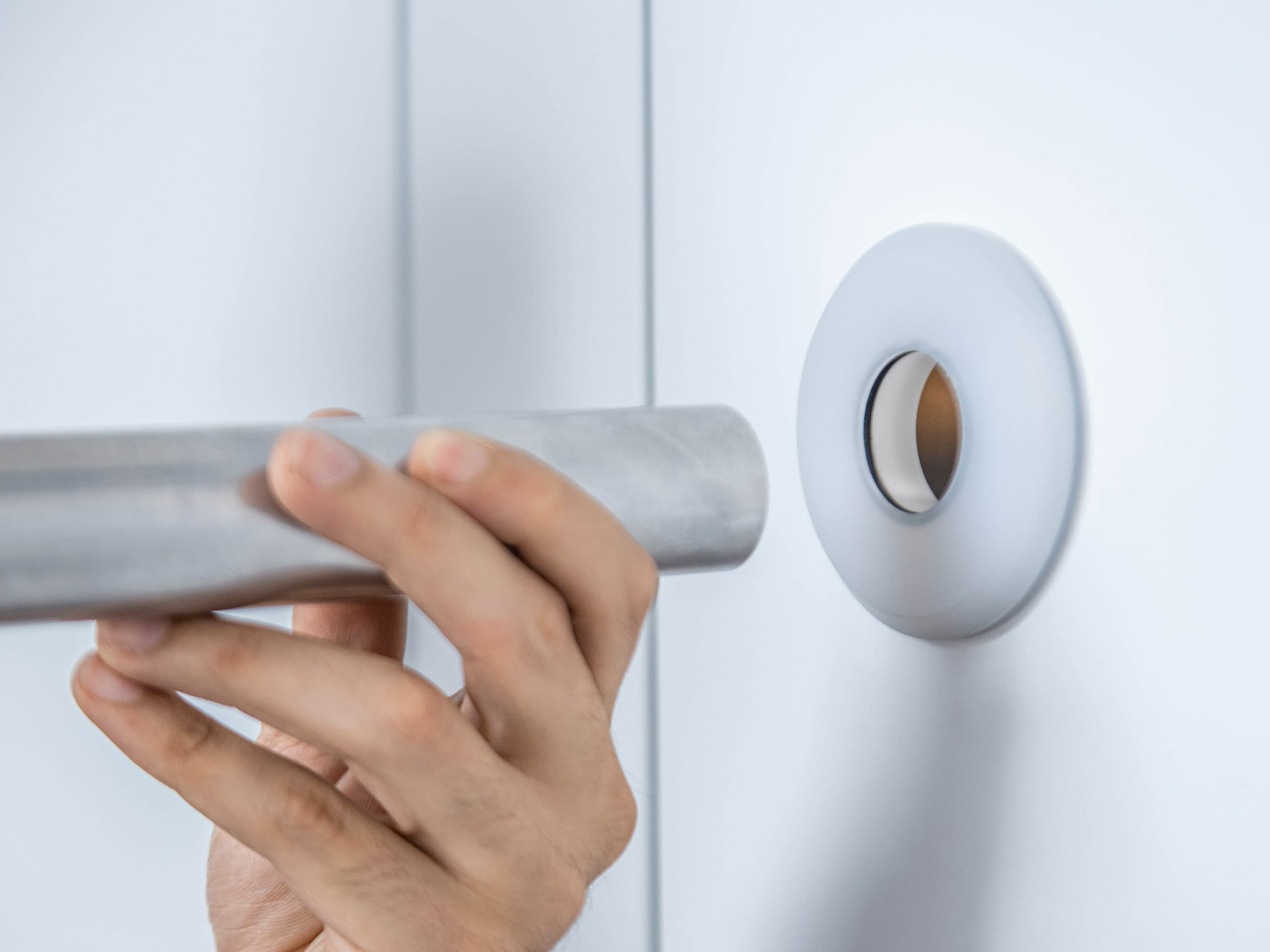 CleanShut as a wall feed-through in use; a hand pushes the tube through