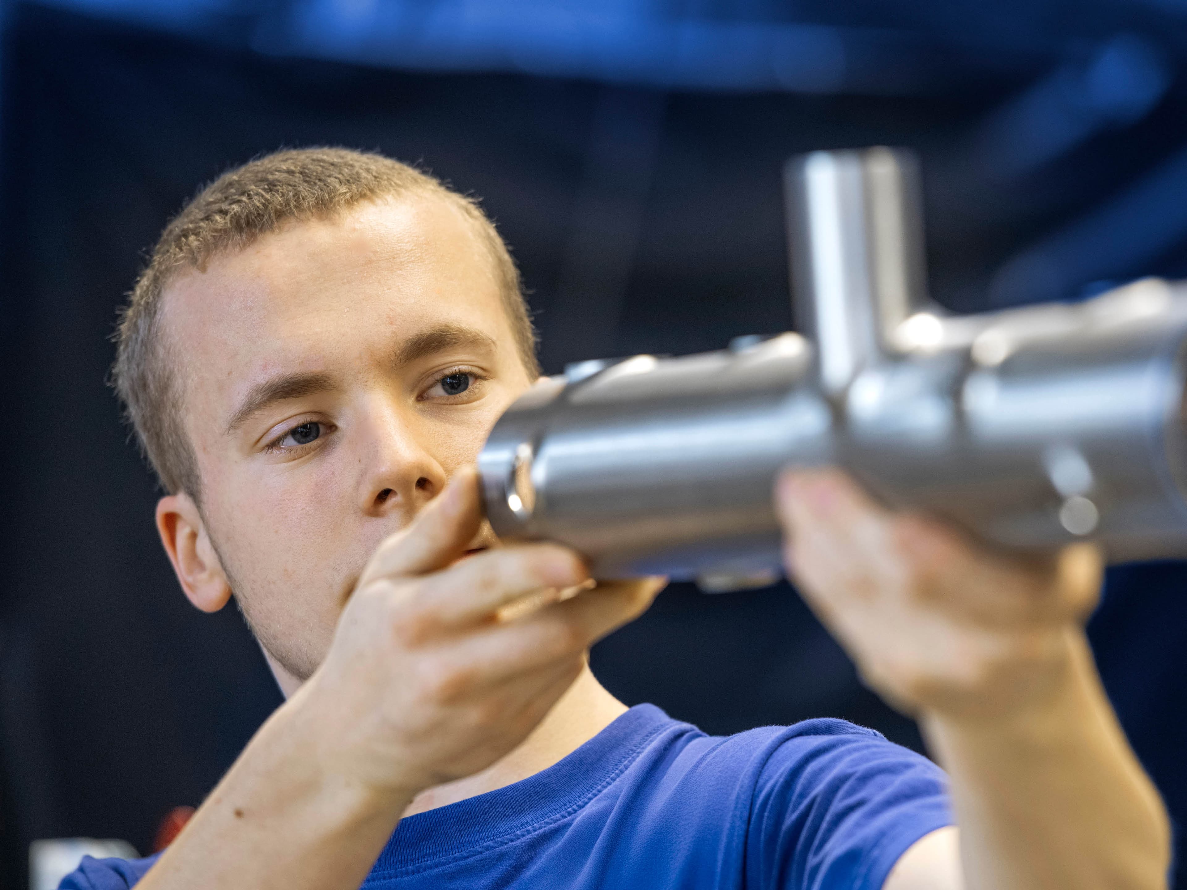 Employee checks stainless steel manifold with closely spaced outlets